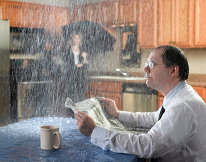 homeowner suffering due to water damage while reading the newspaper and getting drenched in water